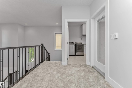 Upper-level hallway featuring light gray carpeting and recessed lighting - 3310 Watson Bay, Edmonton, AB 