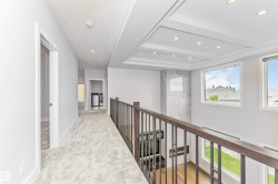 Upper level hallway featuring light gray carpet, recessed lighting, and a coffered ceiling detail - 