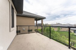 Exterior balcony featuring a glass railing system and a textured surface - 