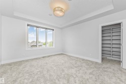 Spacious room featuring plush grey carpeting and a large window with white trim - 