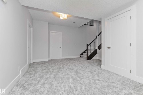 Spacious room featuring light gray carpeting, crisp white walls, and bright white trim - 3310 Watson Bay, Edmonton, AB 