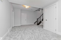 Spacious room featuring light gray carpeting, crisp white walls, and bright white trim - 