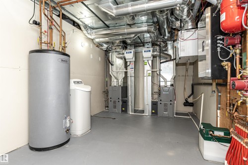 Utility room featuring a water heater, water softener, multiple furnaces, and extensive ductwork - 3310 Watson Bay, Edmonton, AB 