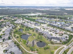 Residential community featuring diverse architectural styles, landscaped green spaces, and multiple water features - 
