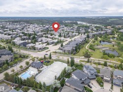 Suburban neighborhood featuring varied residential architecture, established streetscapes, and a prominent green space with water features - 