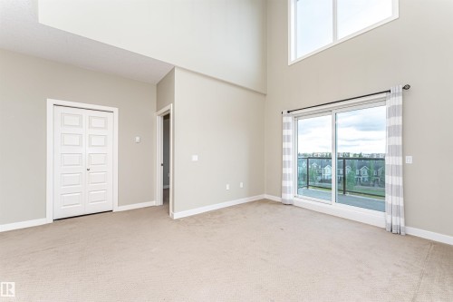 Expansive room with vaulted ceilings and neutral carpeting - 505 1230 Windermere Way, Edmonton, AB 