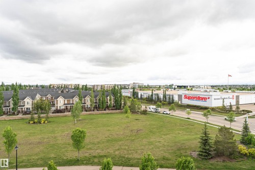 Expansive green space featuring scattered young trees and a paved path - 505 1230 Windermere Way, Edmonton, AB 