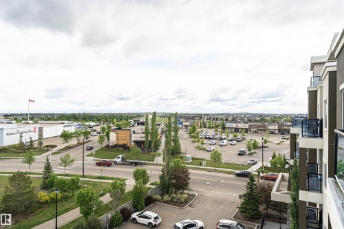Elevated perspective capturing a commercial district with multiple retail establishments, surface parking lots, and paved roadways - 505 1230 Windermere Way, Edmonton, AB 