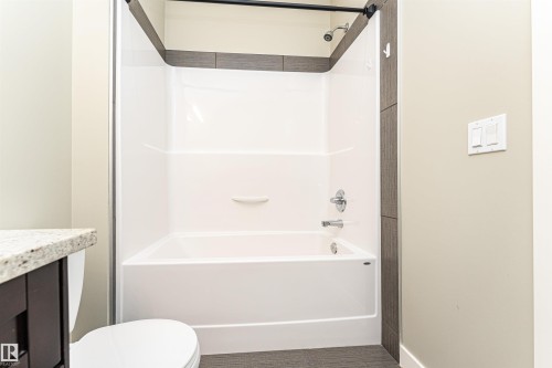 Bathroom featuring a combination tub/shower unit with a shower curtain rod - 505 1230 Windermere Way, Edmonton, AB 