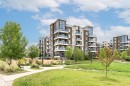 Multi-story residential building featuring dark brown and light beige siding with stone accents - 505 1230 Windermere Way, Edmonton, AB 