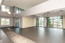 Spacious lobby featuring large format tile flooring, expansive window walls, and recessed lighting - 505 1230 Windermere Way, Edmonton, AB 