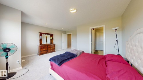 Carpeted interior room featuring light-toned walls, recessed lighting, and a visible doorway with a white panel door - 607 31 Avenue, Edmonton, AB 