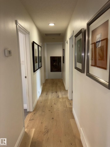 Hallway featuring light wood-finish flooring, recessed ceiling lighting, and white baseboards - 14016 85 Avenue, Edmonton, AB 