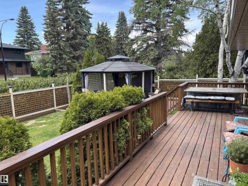 Expansive wood deck with a built-in bench, offering ample space for outdoor enjoyment - 14016 85 Avenue, Edmonton, AB 