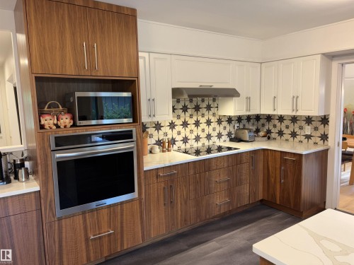 Modern kitchen featuring two-tone cabinetry, a built-in stainless steel oven, and a built-in microwave - 14016 85 Avenue, Edmonton, AB 
