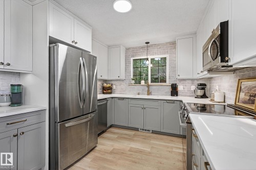 New custom-built kitchen, with quartz counter tops.  Plenty of drawers and cabinets with hidden drawers. Brick backsplash, countertop lighting, floor to ceiling cabinets - 9 Millgrove Drive, Spruce Grove, AB 