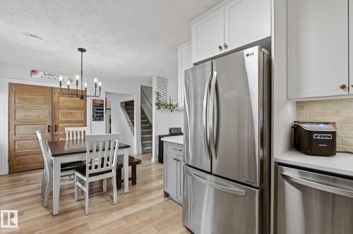 Open-concept kitchen and dining area featuring stainless steel appliances, new flooring - 9 Millgrove Drive, Spruce Grove, AB 