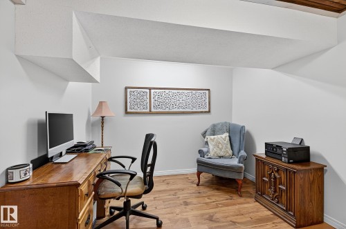 Office space featuring wood-finish flooring, white walls, and a recessed ceiling beam - 9 Millgrove Drive, Spruce Grove, AB 