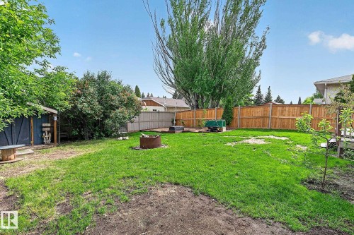 Spacious backyard featuring a lawn area, perimeter fencing, and mature trees - 9 Millgrove Drive, Spruce Grove, AB 