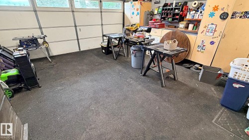 Attached garage with a roll-up door featuring upper translucent panels - 9 Millgrove Drive, Spruce Grove, AB 