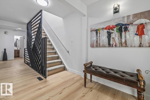 Contemporary staircase featuring a black geometric railing and carpeted treads - 7 Glacier Place, St. Albert, AB 