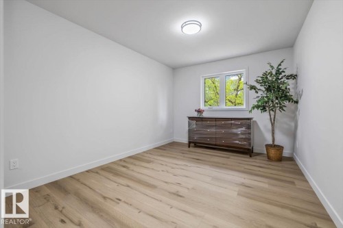 Light-filled room featuring wood-finish flooring, white baseboards, and a modern ceiling light fixture - 7 Glacier Place, St. Albert, AB 