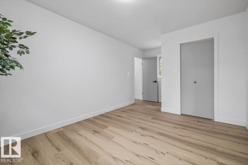 Bright interior space featuring light wood-finish flooring, white walls, and white baseboards - 7 Glacier Place, St. Albert, AB 