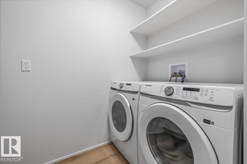 Dedicated laundry area featuring a light wood-finish floor, white baseboards, and neutral wall tones - 7 Glacier Place, St. Albert, AB 