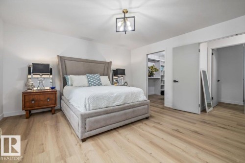 Spacious room featuring wood-finish flooring, a contemporary ceiling fixture, and a walk-in closet with built-in shelving - 7 Glacier Place, St. Albert, AB 