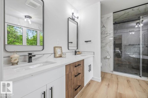 Dual vanity featuring white countertops, integrated sinks, and matte black fixtures - 7 Glacier Place, St. Albert, AB 