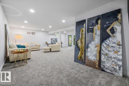 Spacious lower-level area featuring light gray carpeting, recessed ceiling lighting, and crisp white walls - 7 Glacier Place, St. Albert, AB 