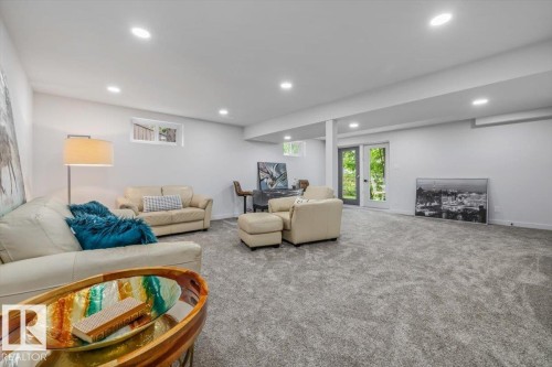 Expansive recreation room featuring light gray carpeting, recessed lighting, and white painted walls - 7 Glacier Place, St. Albert, AB 