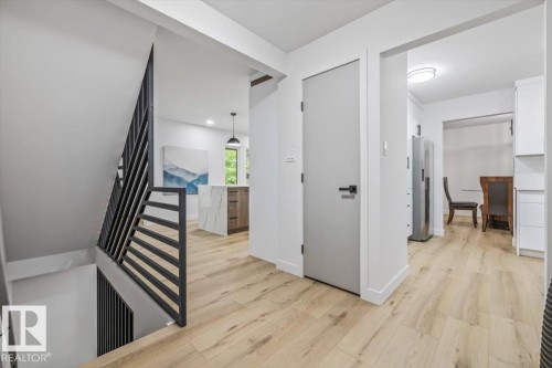 Contemporary metal staircase railing with light wood-finish flooring - 7 Glacier Place, St. Albert, AB 