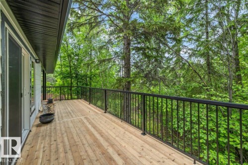 Expansive outdoor deck featuring natural wood flooring and black metal railings - 7 Glacier Place, St. Albert, AB 