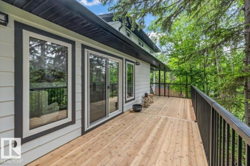 Expansive wood deck with black metal railings, white siding, and a dark fascia - 7 Glacier Place, St. Albert, AB 