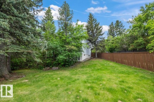 Expansive grassy yard with mature trees and a privacy fence - 7 Glacier Place, St. Albert, AB 