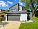 Contemporary architectural exterior featuring a prominent garage, a gabled roofline, and varied facade materials including vertical siding and white brick - 38 Woodcrest Avenue, St. Albert, AB 