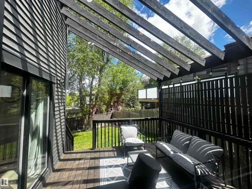 Expansive outdoor deck featuring wood-finish flooring, a slatted pergola, and a privacy screen - 38 Woodcrest Avenue, St. Albert, AB 
