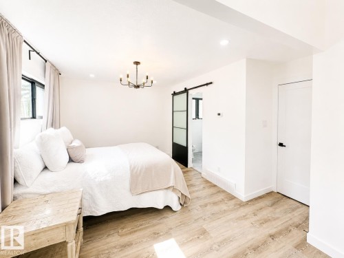 Bright interior featuring light wood-finish flooring, recessed lighting, and a modern chandelier - 38 Woodcrest Avenue, St. Albert, AB 