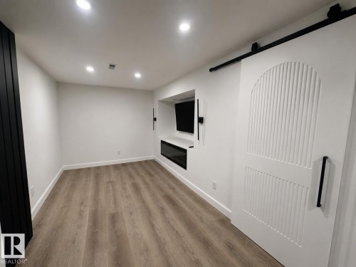 Spacious room featuring wood-finish flooring and a white color palette - 38 Woodcrest Avenue, St. Albert, AB 