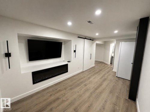 Entertainment wall featuring a built-in media niche, electric fireplace, and accent lighting - 38 Woodcrest Avenue, St. Albert, AB 