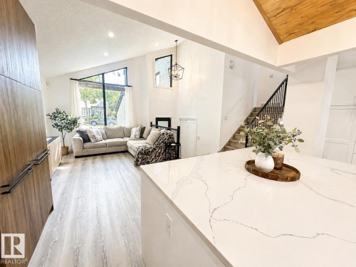 Open-concept kitchen and living area featuring high ceilings and light wood-finish flooring - 38 Woodcrest Avenue, St. Albert, AB 