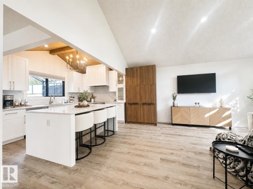 Expansive kitchen with a large central island, white cabinetry, and a patterned backsplash - 38 Woodcrest Avenue, St. Albert, AB 