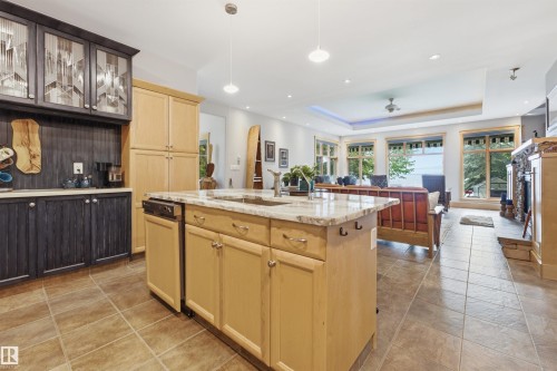 Kitchen island with stone countertop, integrated sink, and dishwasher - A38 Bernice Ave, Rural Leduc County, AB 