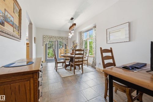 Dining area featuring tile flooring, a multi-bulb chandelier, and French doors leading to exterior - A38 Bernice Ave, Rural Leduc County, AB 