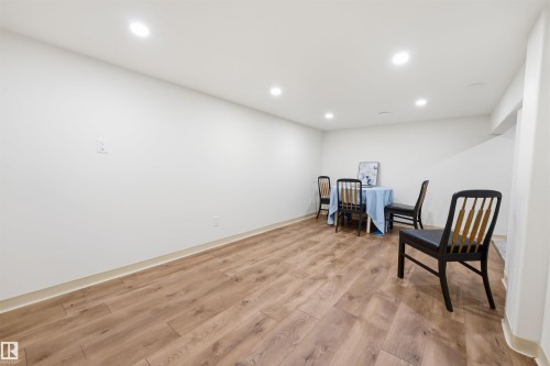 Spacious interior room featuring wood-finish flooring, recessed lighting, and a neutral color palette - A38 Bernice Ave, Rural Leduc County, AB 
