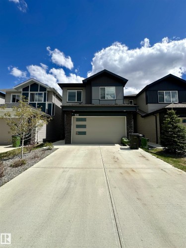 Contemporary two-story exterior with a contrasting façade, integrated garage with frosted glass panels, and a concrete driveway - 5211 Kimball Crescent, Edmonton, AB 