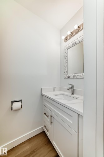 White vanity with a built-in rectangular sink, light countertop, and brushed nickel hardware - 9D Castle Terrace, Edmonton, AB 