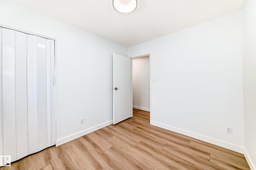 Room featuring light wood-finish flooring, white walls, and a white ceiling with a flush-mount light fixture - 9D Castle Terrace, Edmonton, AB 
