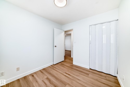 Bright interior space featuring wood-finish flooring, white walls, and a ceiling-mounted light fixture - 9D Castle Terrace, Edmonton, AB 